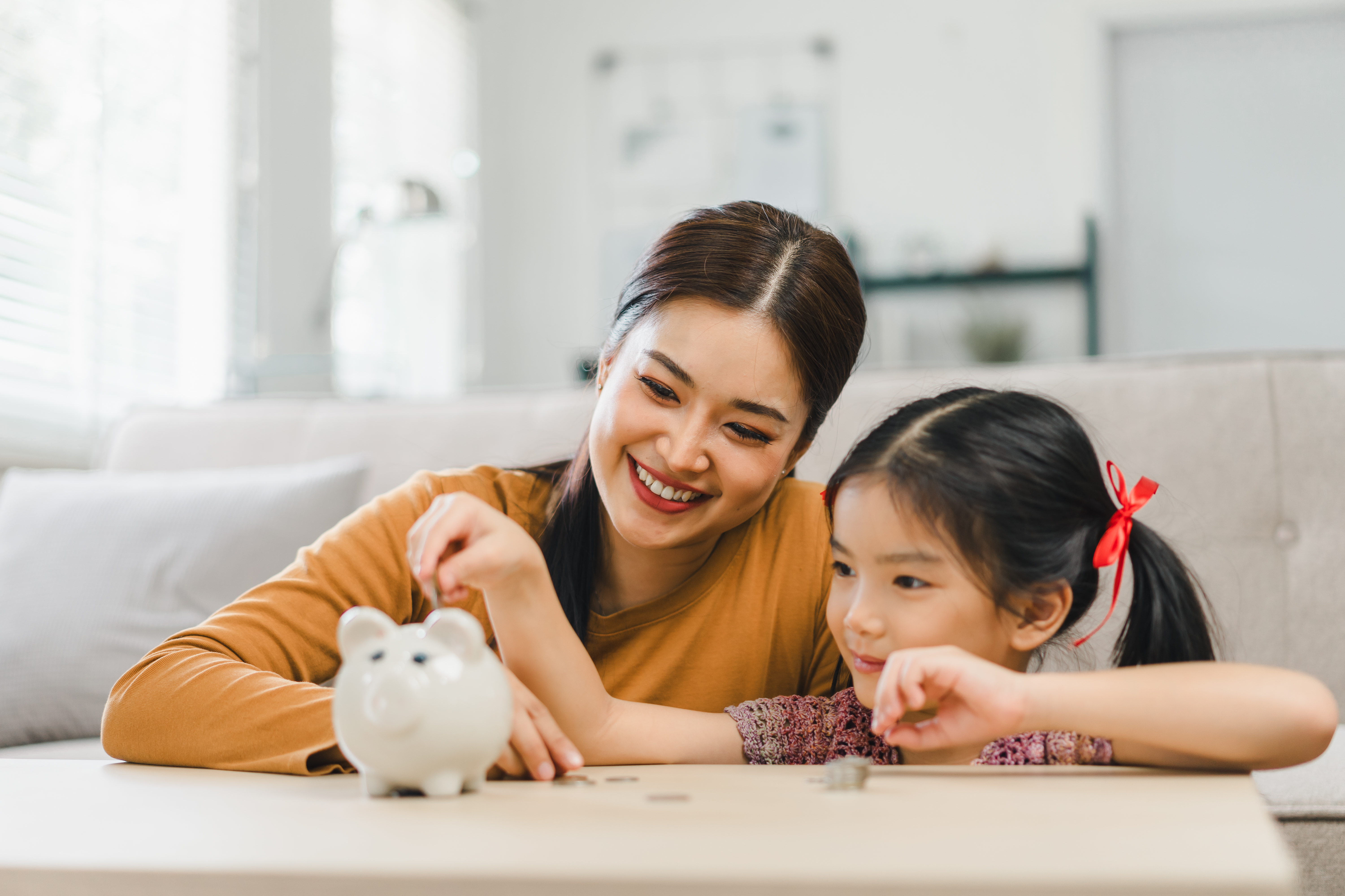 Mother and daughter saving coins